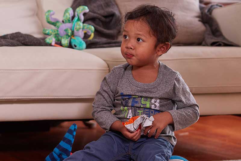 toddler snacking while playing